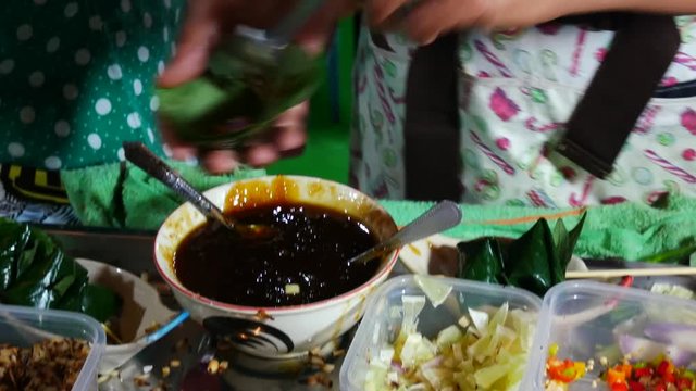 People are doing the Miang Kum (Leaf-Wrapped Bite-Size Appetizer) popular foods Thailand.