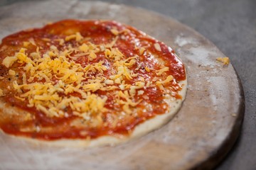 Pizza dough with tomato sauce with grated cheese