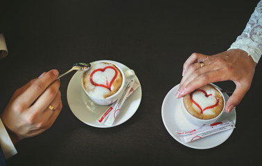 Couple in love holding hands with coffee on a table