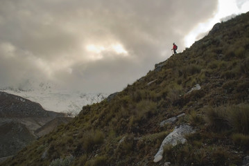 Hiker gazing at the glacier in the glacial valley in the desolate peruvian mountain landscape