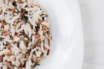 Close up of Plate of cooked mixed rice on white background. Brown, red and black rice mix
