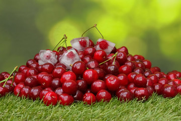 Kirschen im Gras mit einigen Kirschen in Eiswürfeln