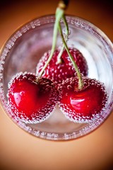 Red fresh cherry in water with water bubbles