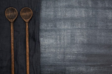 Wooden spoon on a dark table. For your design.
