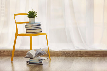 Pile of books and chair in modern interior