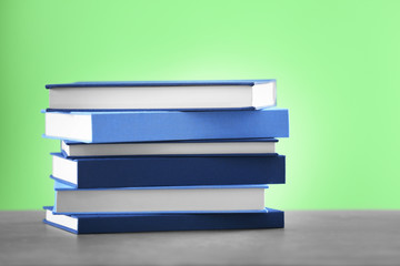 Pile of books on wooden table and green  background