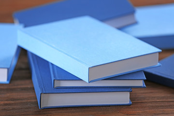 Pile of blue books on wooden background