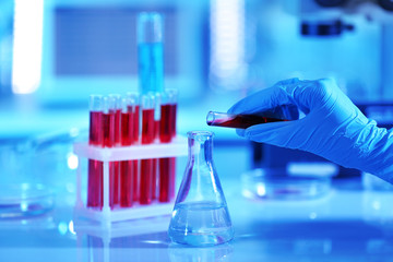 Scientist hand and test tubes with blood in laboratory