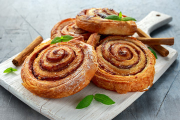 Freshly Baked Traditional Sweet Cinnamon Rolls, Swirl on white wooden board