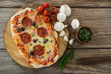 Various species with pizza and tomato on a wooden tray