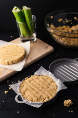 Raw veggie burgers on a rustic wooden chopping board