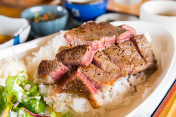 medium rare wagyu beef steak with Japanese rice and vegetable salads on the side