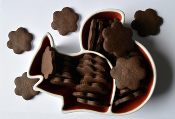 Stack of homemade dark chocolate flower shaped cookies  in squirrel plate