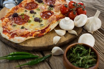 Various species with pizza and tomato on a wooden tray