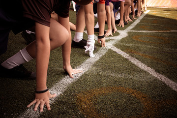 Students boy get set to leaving the starting for running competition boy at school sports day....