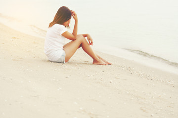 Fototapeta na wymiar Asian young female feeling sad and lonely on the beach