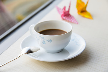 hot coffee by the window with colorful origami crane