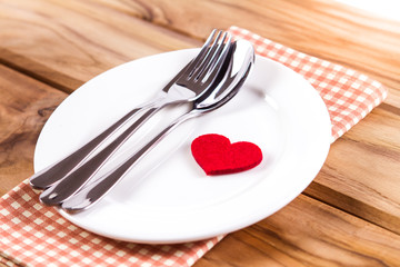 red heart shape with White empty plate with fork and spoon 