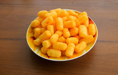 Corn sticks in bowl on wooden table