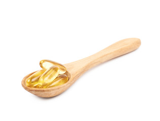 Wooden spoon full of softgel pills