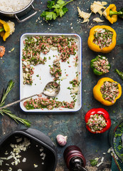 Bell colorful paprika peppers stuffing preparation with rice and mincemeat on rustic kitchen table background, top view
