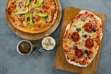 pizza served on a chopping board with a beer 