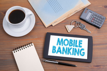 Mobile banking, business concept. Text on tablet device on a wooden table.