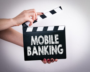 Mobile banking concept. Female hands holding movie clapper. 