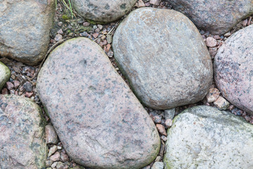 Old road paved of stones. Cobble background