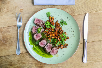 Beef tenderloin with fried chanterelles lying on a plate.