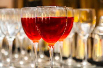 A glass of red or pink wine in front of empty glasses.