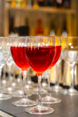 A glass of red or pink wine in front of empty glasses.