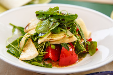 Salad with spinach, tomatoes and grilled cheese lie t on the pla