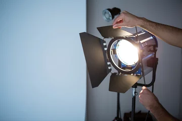 Rolgordijnen Photographer adjusting spotlight © WavebreakMediaMicro