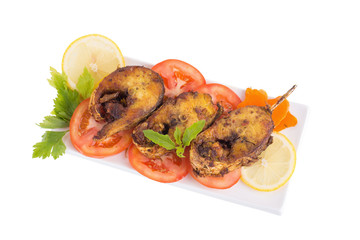 Fried fish in a plate with ingredients