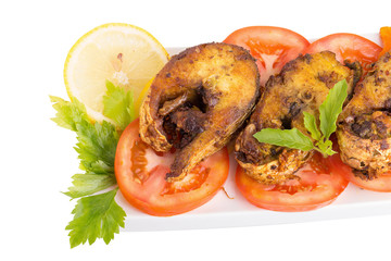 Fried fish in a plate with ingredients
