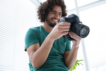 Photographer reviewing captured photos in his digital camera