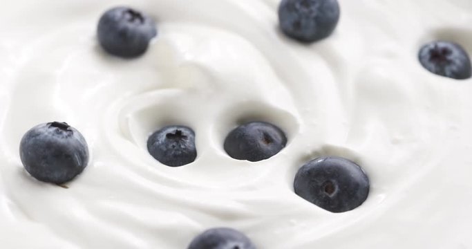Blueberries in organic yogurt rotating loop video, 4k prores footage