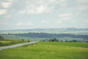 Fototapeta na wymiar Hills covered with green grass under blue sky