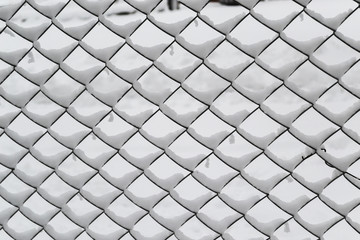 Fence from metallic net with snow