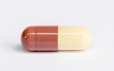 close up of one capsule isolated on white background