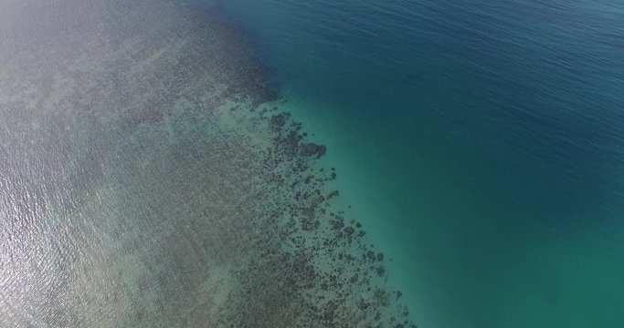 Aerial footage. Flying close over tropical ocean water. Coral reefs. Thailand. Phuket. Layan beach. 4K