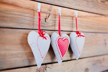 Textile hearts on old rustic wooden background.