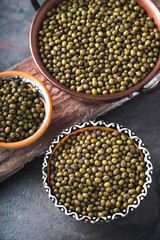 Green mung beans in bowls on wooden stand