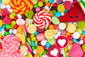 Sucettes colorées et bonbons ronds de différentes couleurs.