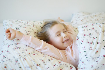 Adorable little girl sleeping in a bed