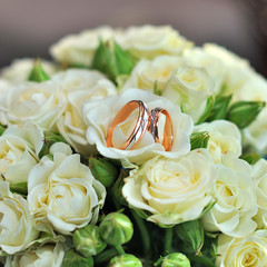 Closeup of a beautiful wedding bouquet with ribbon for bride close rings. White background.