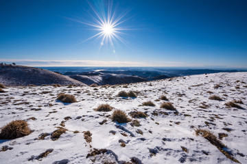 Sun over snowcapped mountain