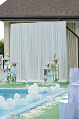 Decorations for the wedding ceremony by the pool with blue water.