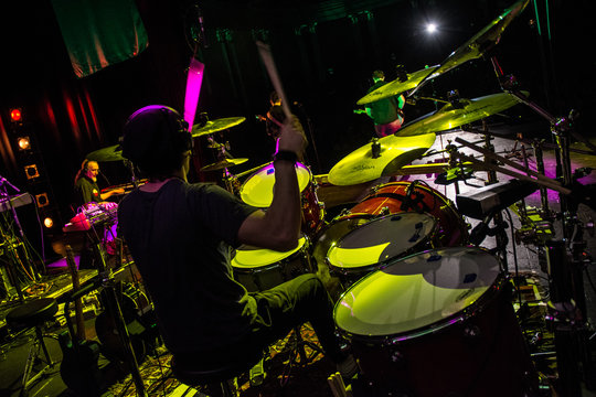 Batterista suona sul palco assolo di batteria durante il concerto, effetto fumo e luci.